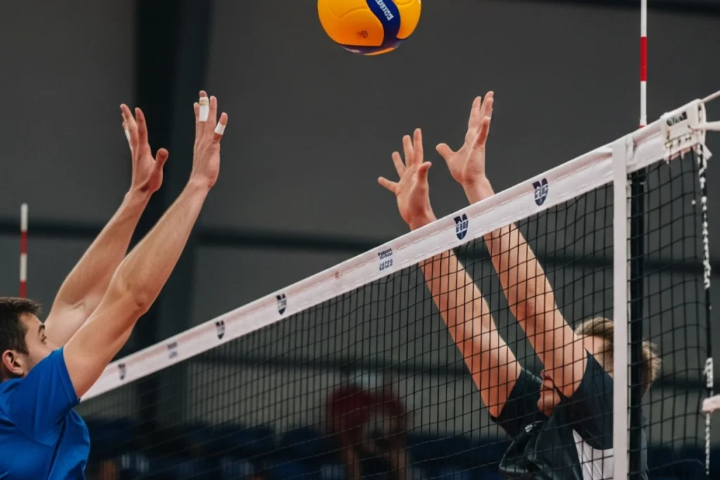 Bola de voleibol sobre uma rede durante um jogo indoor profissional